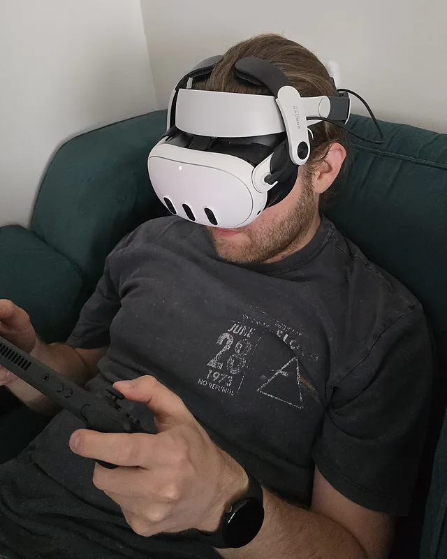 Tomek wearing a VR headset and holding a Steam Deck